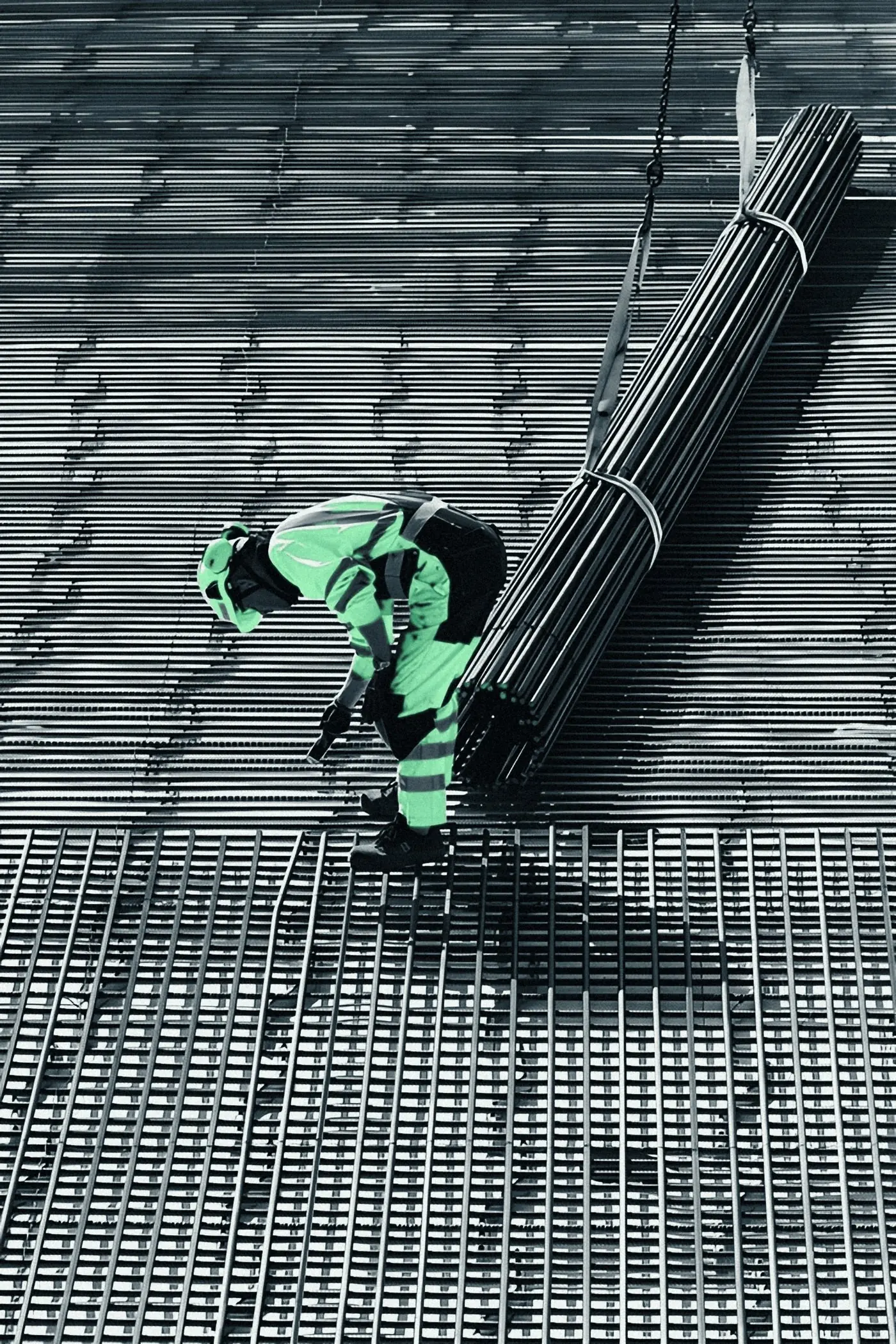 Steel fixer in a hi-vis vest bundling reinforcement on site